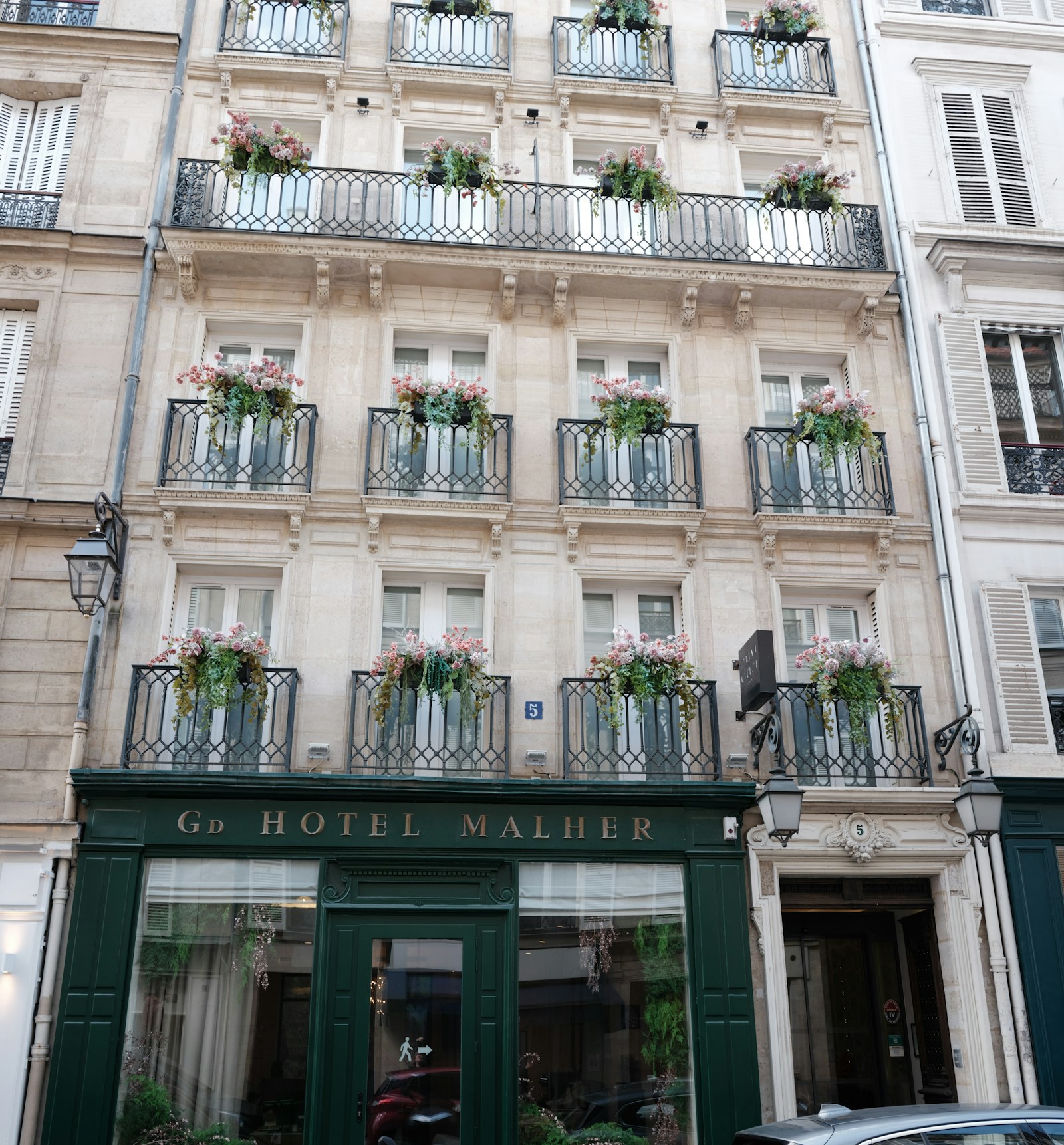 Characterful European boutique hotel façade with balconies and flowers